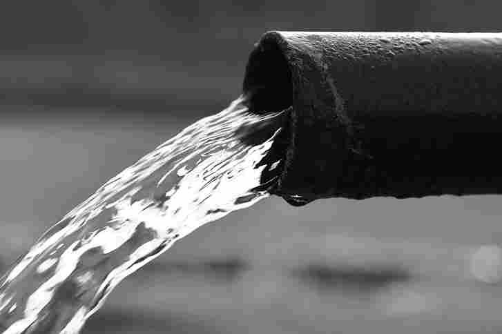 Questa è un'immagine in bianco e nero di un tubo da dove sgorga acqua