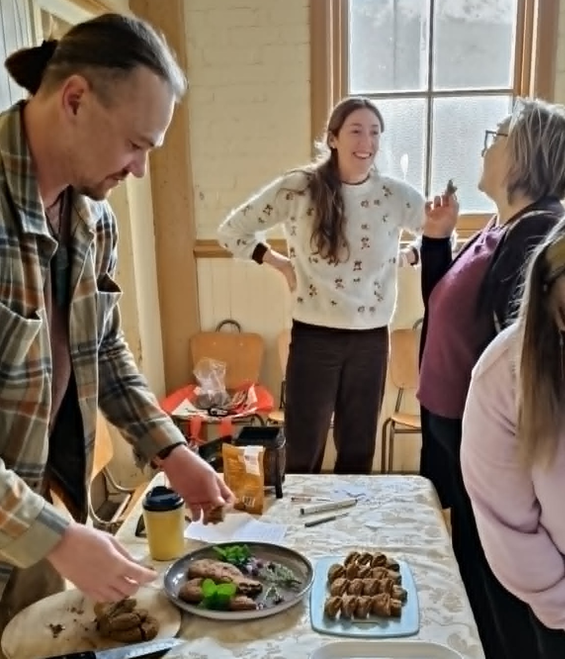 I love this photo as it captures Beth's partner Dan cutting the entries for our community to judge, Carolyne trying, and being highly impressed, with Beth's entry and Beth enjoying the sun filtering through the window in the background.
