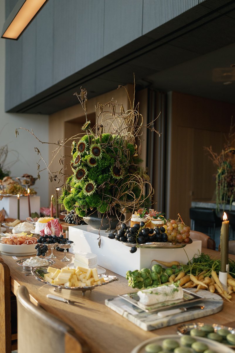 A beautifully arranged buffet table showcases an array of gourmet food items, including cheeses, charcuterie, fresh frui