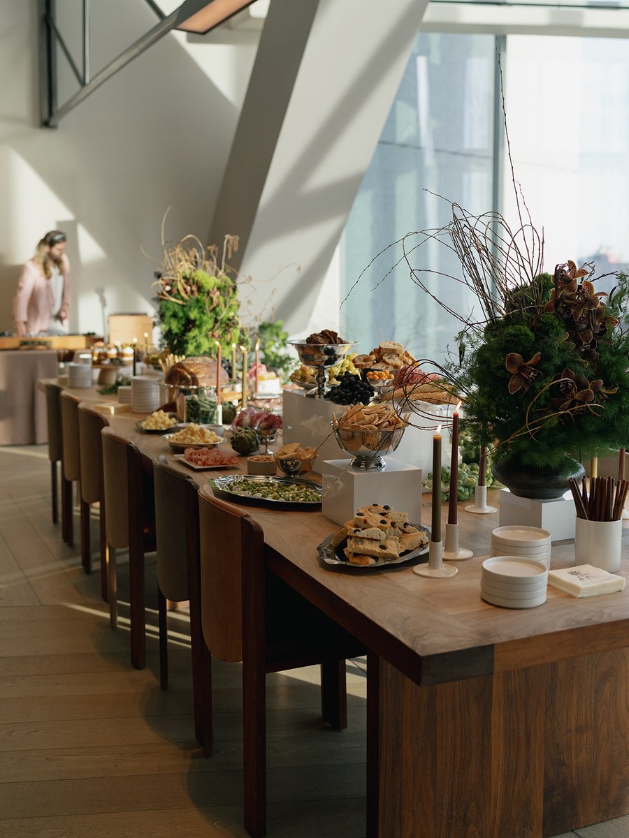 An elegant buffet table is set with a variety of gourmet appetizers and snacks, featuring decorative floral arrangements