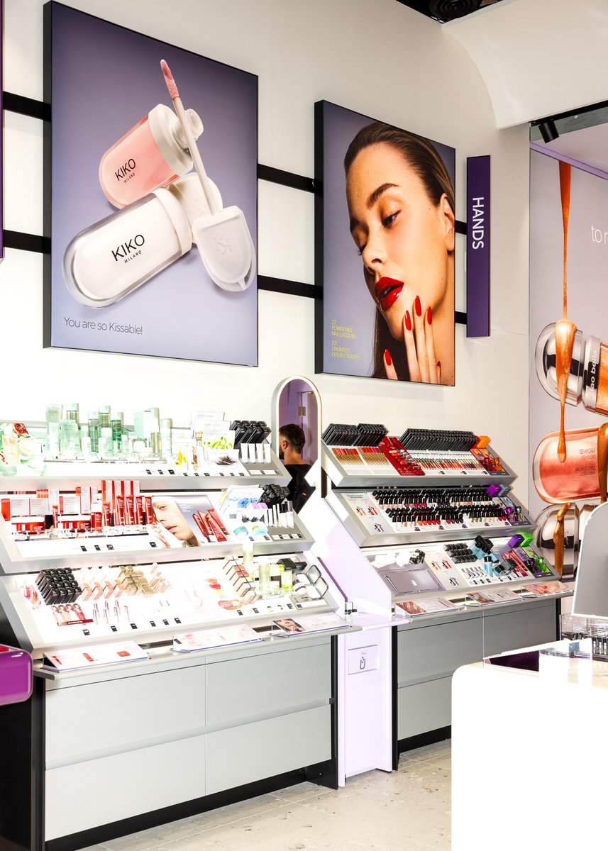 This photo showcases the brightly lit interior of a KIKO Milano cosmetics store, featuring various makeup and skincare p