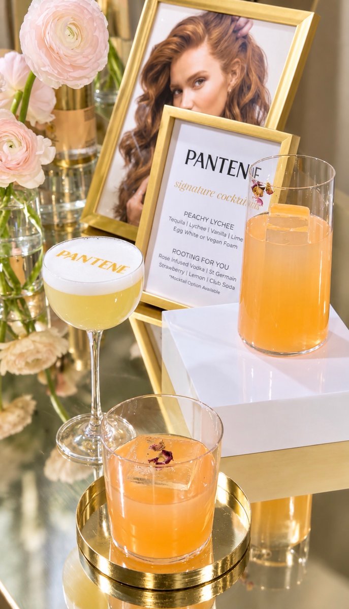 This close-up shot features a vibrant display of signature cocktails for a Pantene event. Two distinct drinks, one with 