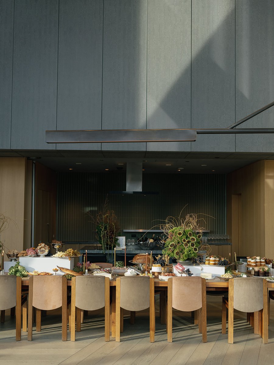 A beautifully arranged buffet table laden with various food items and decorative floral arrangements. The setting featur