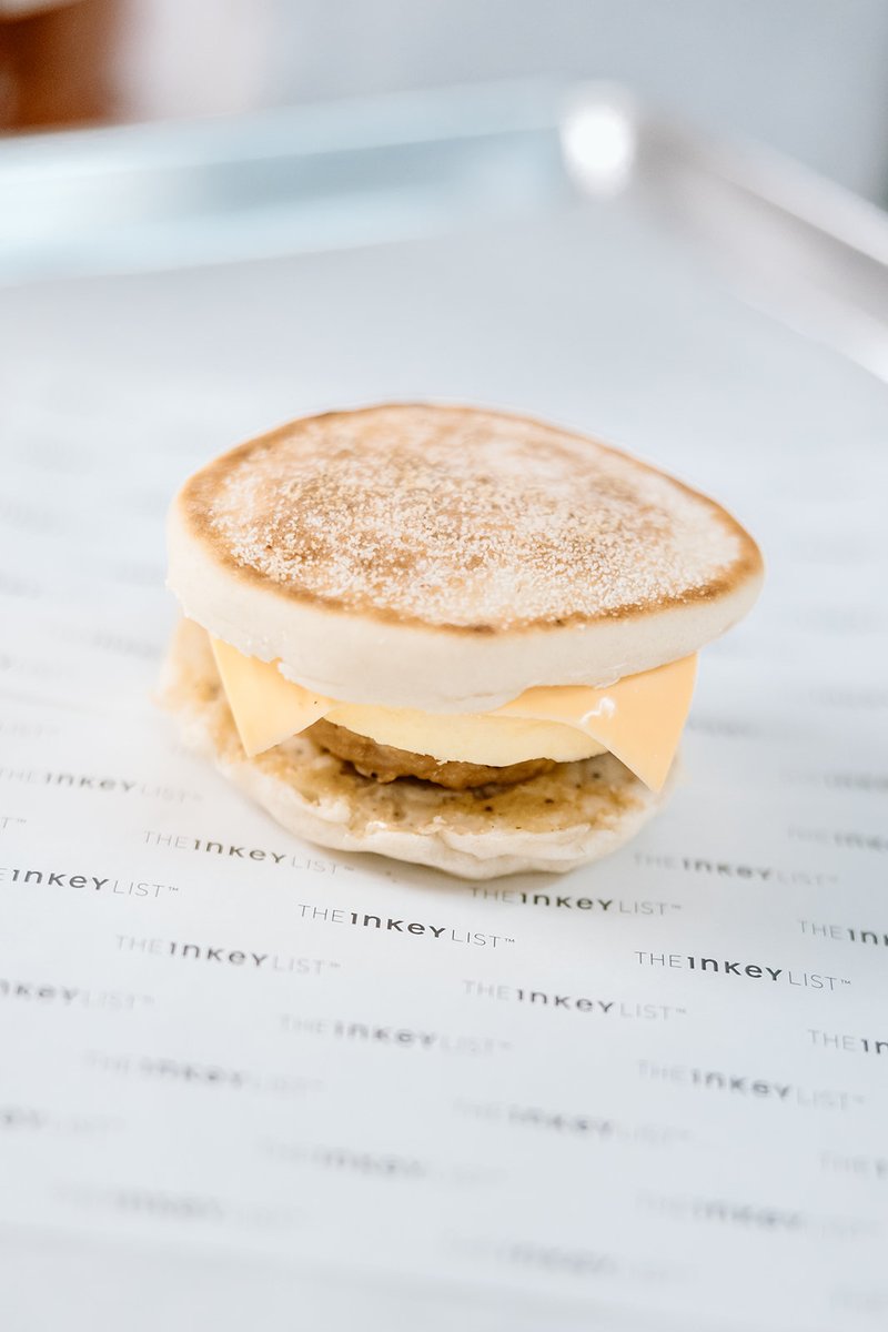 A close-up shot features a breakfast sandwich, likely an English muffin with a melted cheese slice and a breakfast patty