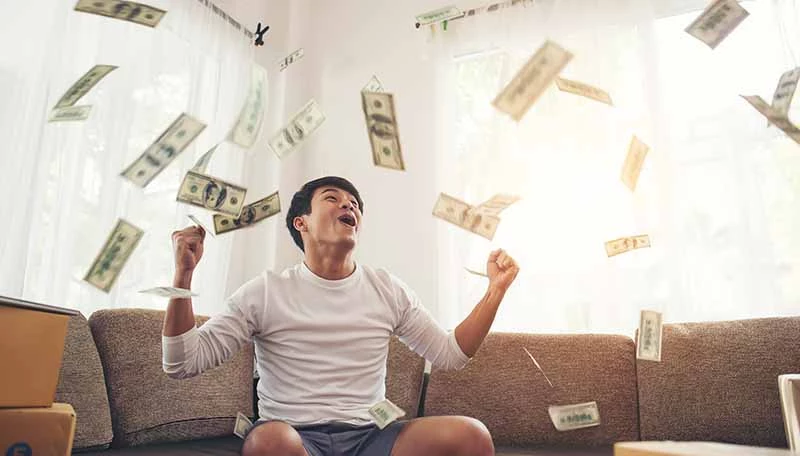 Seseorang bergembira dengan uang berterbangan Refinancing dapat memberikan kucuran dana yang lebih besar