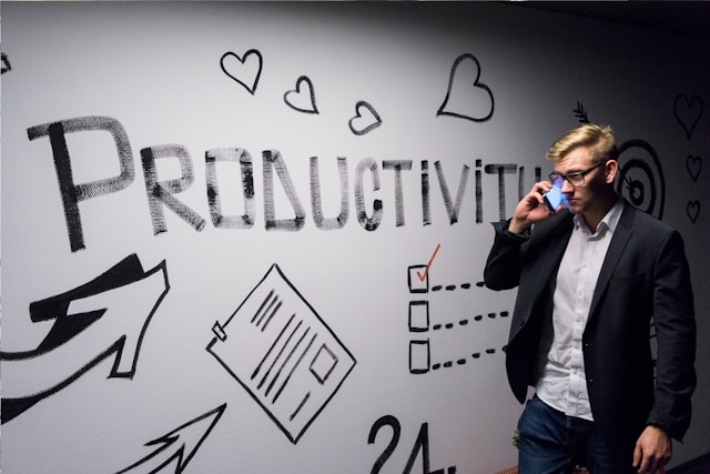 An entrepreneur talking on the phone next to a board with a productivity plan