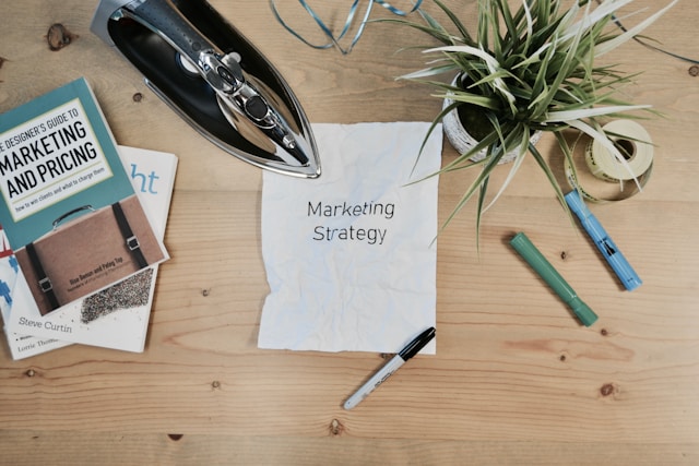 Paper on a table with text "Marketing Strategy". Photo by Campaign Creators.