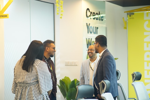 A group of people standing around a table. Photo by Musemind UX Agency.