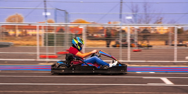 A person riding a go kart in a parking lot. Photo by Sorin Dandu.