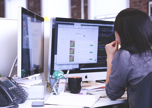 Woman in front of an iMac. Image by StartupStockPhotos