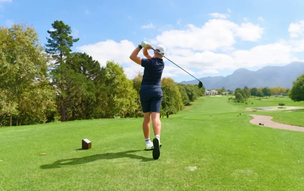 Golfer swinging on a scenic mountain golf course