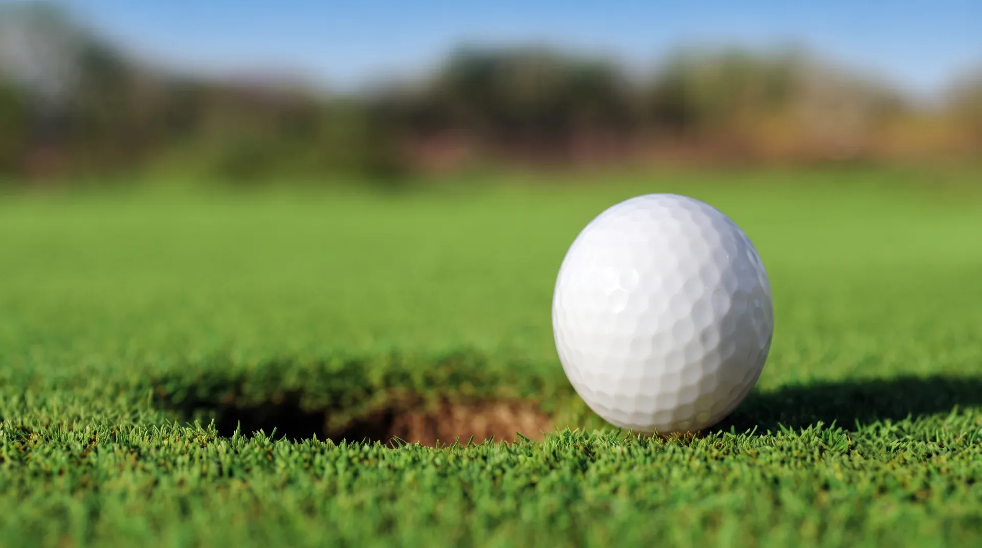 White golf ball near the hole on a putting green
