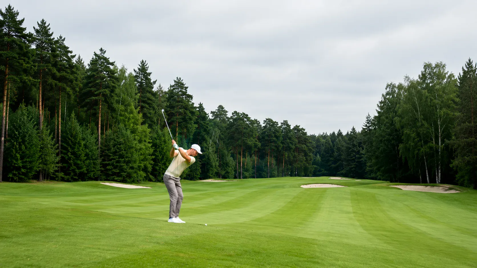 null Golfer swinging on a tree-lined golf course