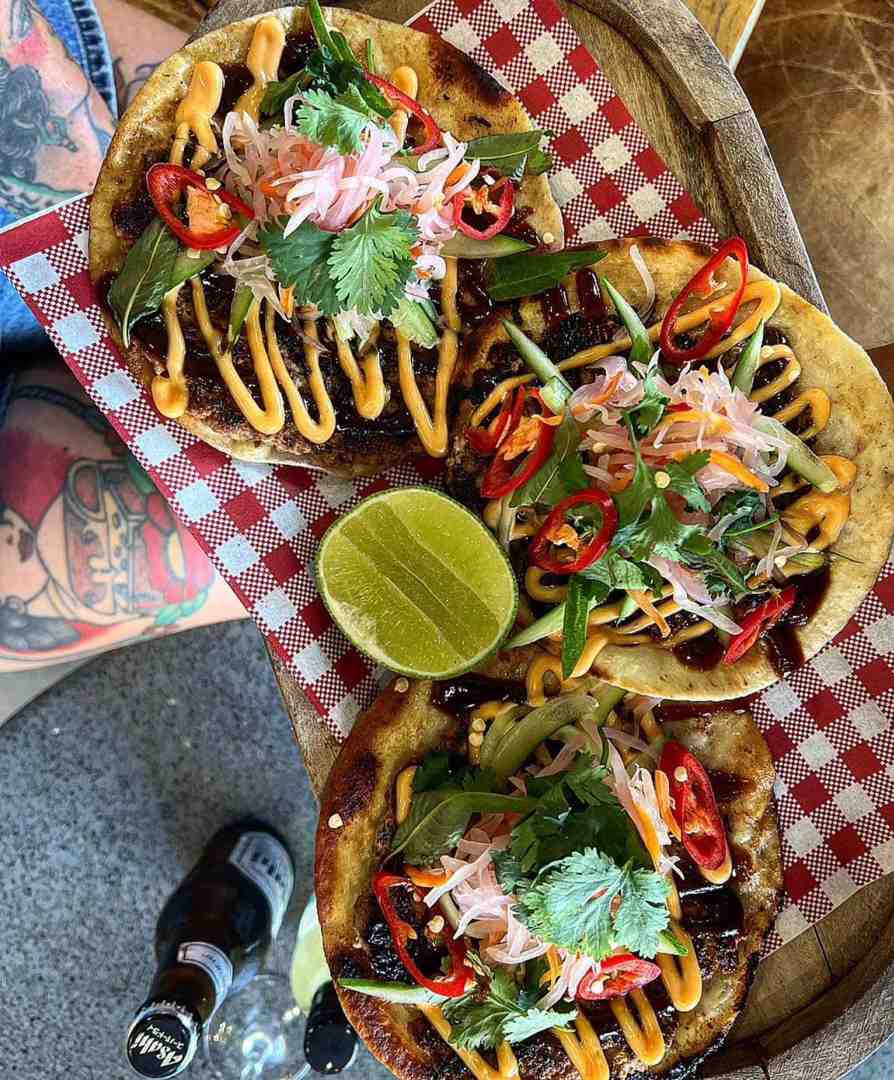 Spicy, delicious soft-shell tacos, served with pickled slaw and coriander on a wooden platter. A fantastic option for the best lunch Sunshine Coast. Spicy, delicious soft-shell tacos, served with pickled slaw and coriander on a wooden platter. A fantastic option for the best lunch Sunshine Coast.
