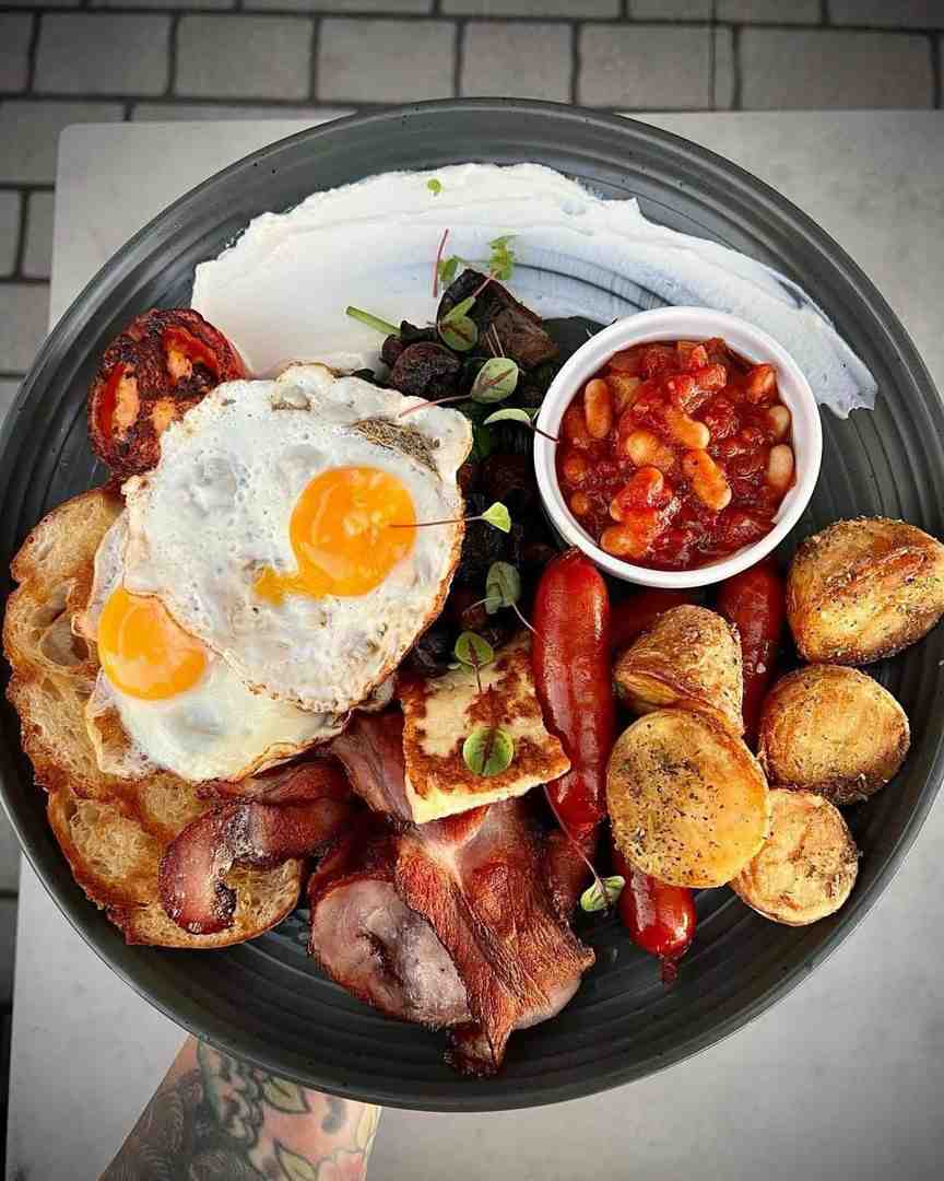 Fuel your remote work session with a huge, premium big breakfast featuring perfectly fried eggs, crunchy bacon, halloumi, and sausages, available at this outstanding work friendly cafe. Fuel your remote work session with a huge, premium big breakfast featuring perfectly fried eggs, crunchy bacon, halloumi, and sausages, available at this outstanding work friendly cafe.
