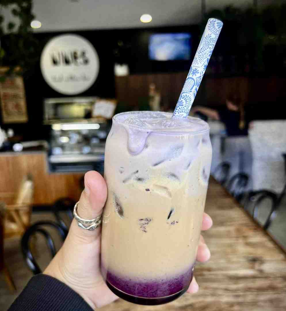 Close-up of an ube-infused iced coffee with a vibrant purple foam, showcasing the creative flavor profiles of our limited time drinks selection.