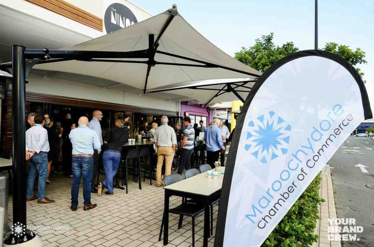 Professionals mingling at an outdoor event at The Nines, featuring the Maroochydore Chamber of Commerce banner. Ideal spot for the best lunch Sunshine Coast. Professionals mingling at an outdoor event at The Nines, featuring the Maroochydore Chamber of Commerce banner. Ideal spot for the best lunch Sunshine Coast.