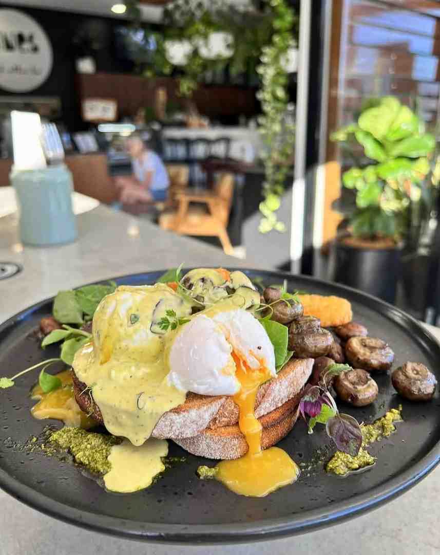 A decadent breakfast plate with herb hollandaise and sautéed mushrooms, showcasing the gourmet details of what is a Benny?