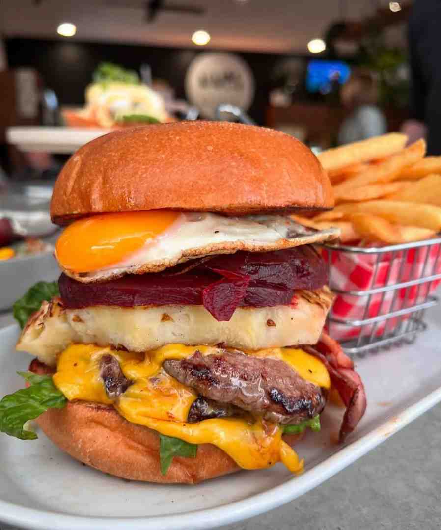 Classic Aussie burger featuring beef brisket, cheese, beetroot, pineapple, and tomato relish served with fries.