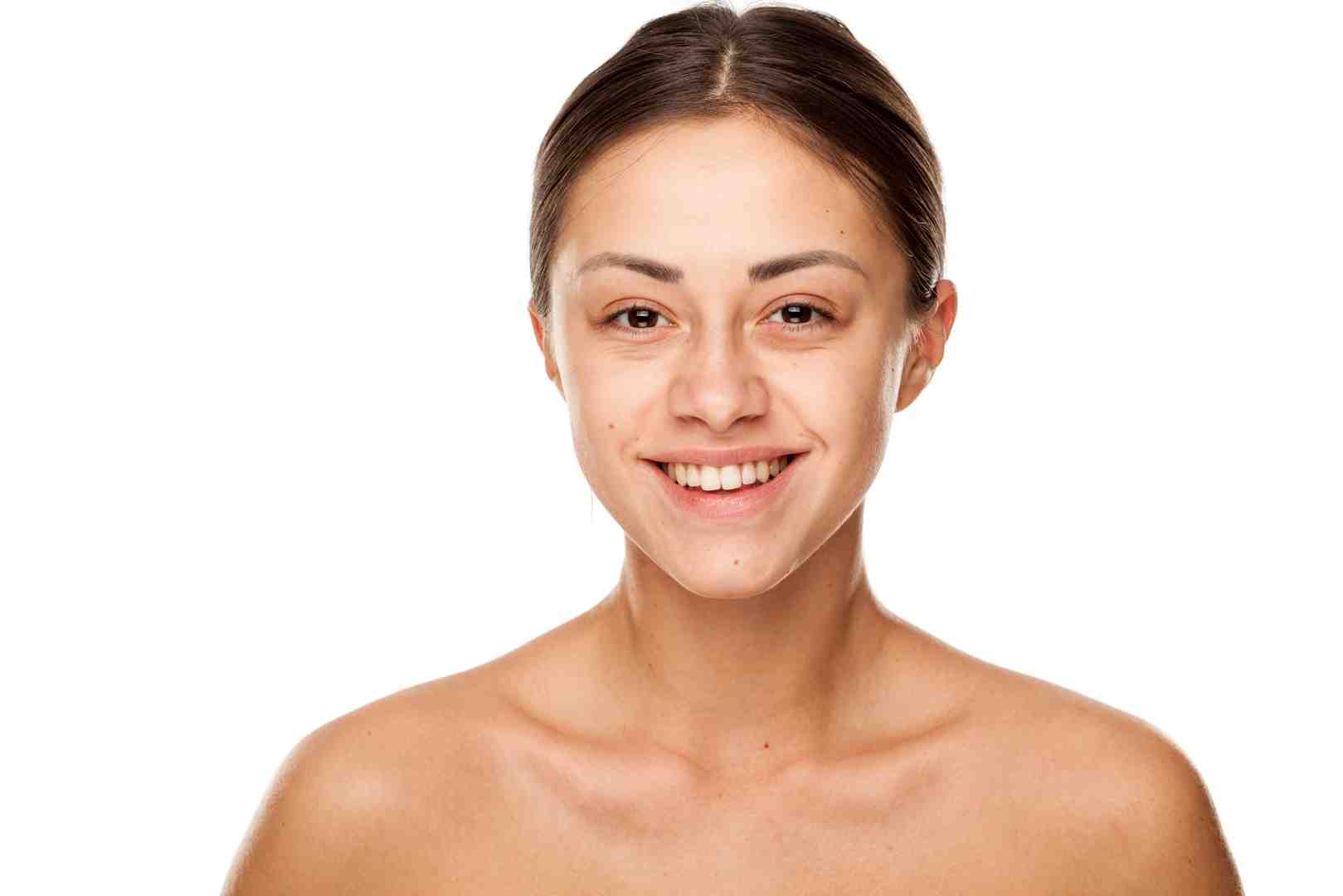 Smiling woman with natural makeup and clear skin against a white background, showcasing healthy, radiant complexion