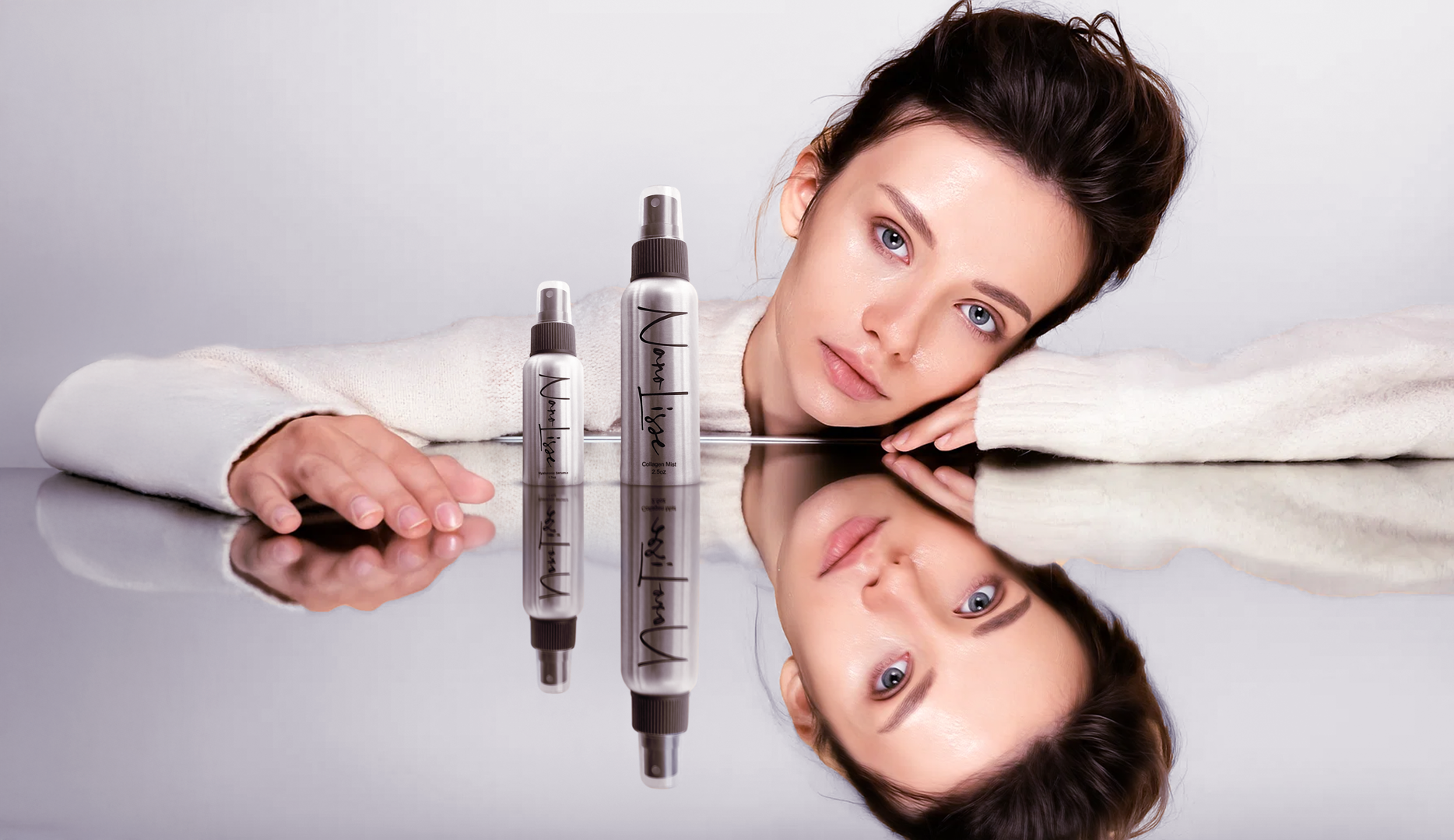 Woman resting beside Nanolisse skincare bottles on a reflective surface, showcasing minimalist skincare products focused on hydration, glow, and simplicity