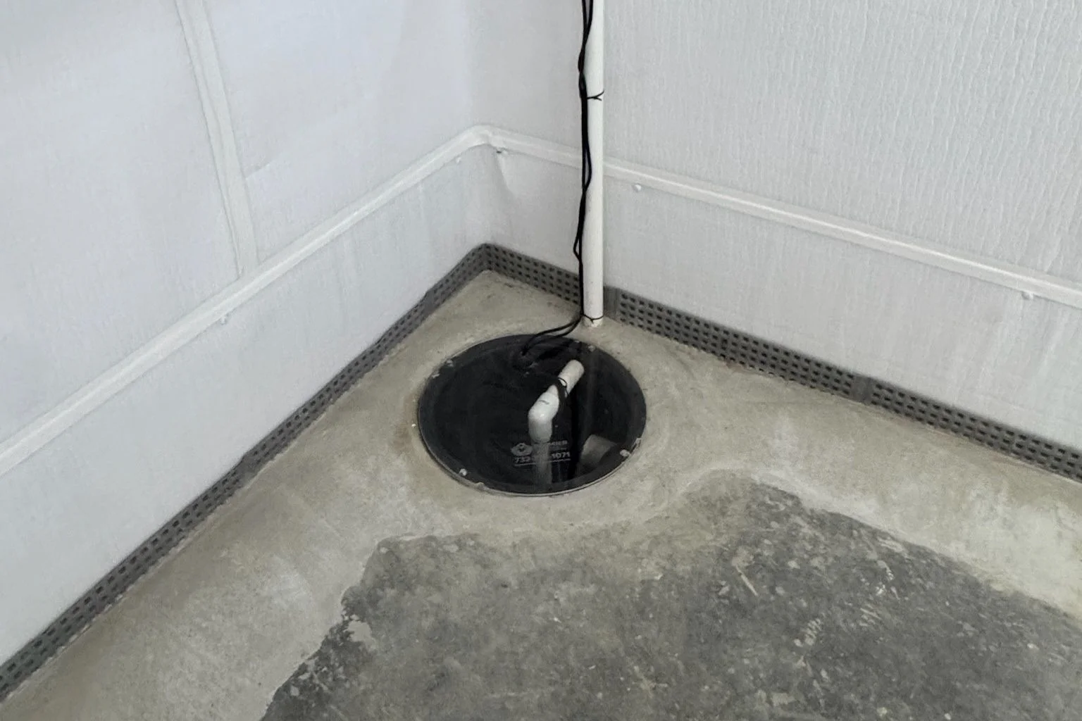 user-inserted Finished dry basement after NJ waterproofing, showing a sump pump.