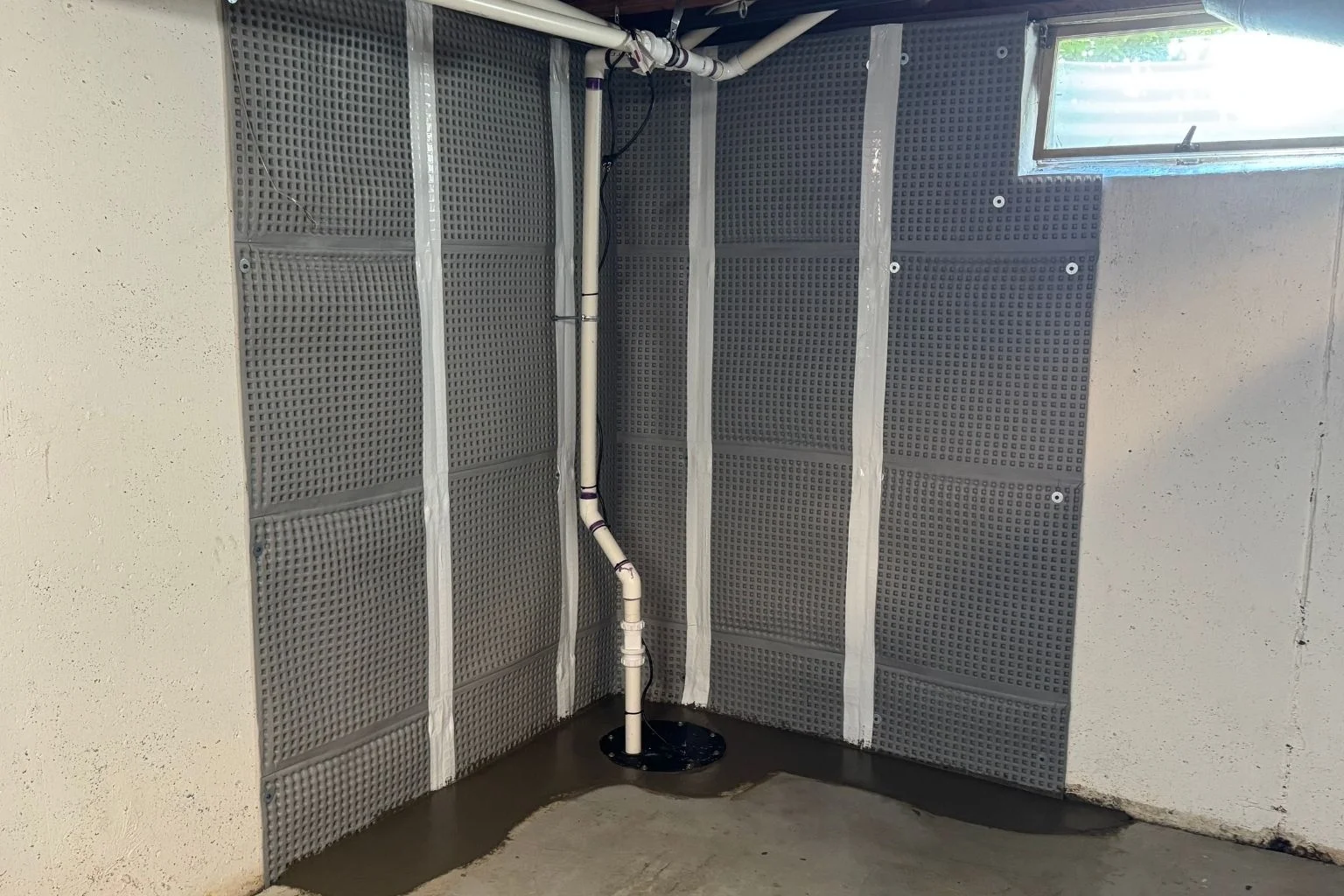 user-inserted Basement waterproofing system installation for lawn and patio drainage.