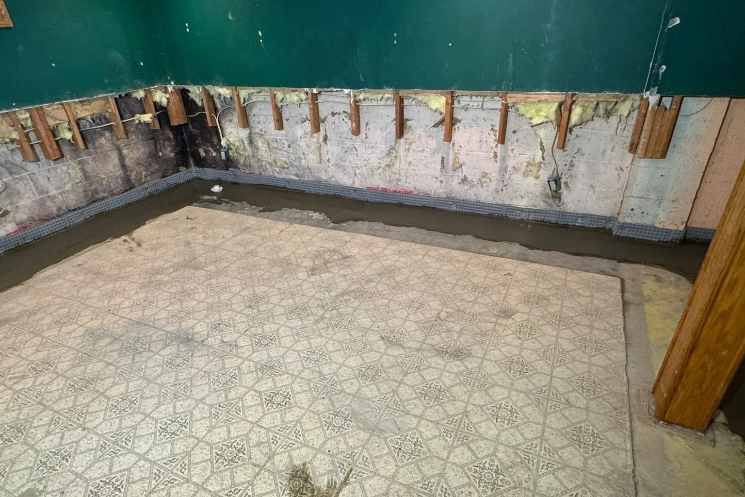 user-inserted Interior French drain system in a basement, illustrating a basement waterproofing solution.