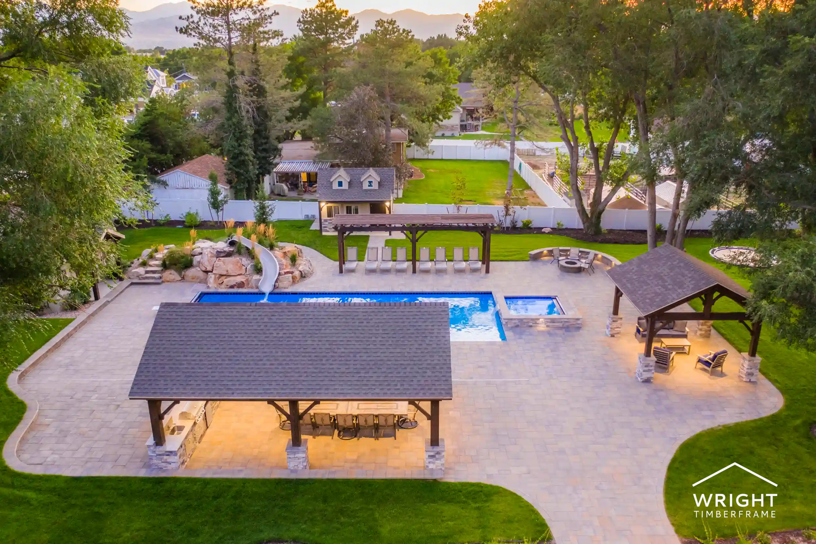 Luxury Timber Frame Outdoor Living Space Aerial view of backyard natural materials outdoor design with timber pavilions, pool, spa, and landscaped patio.