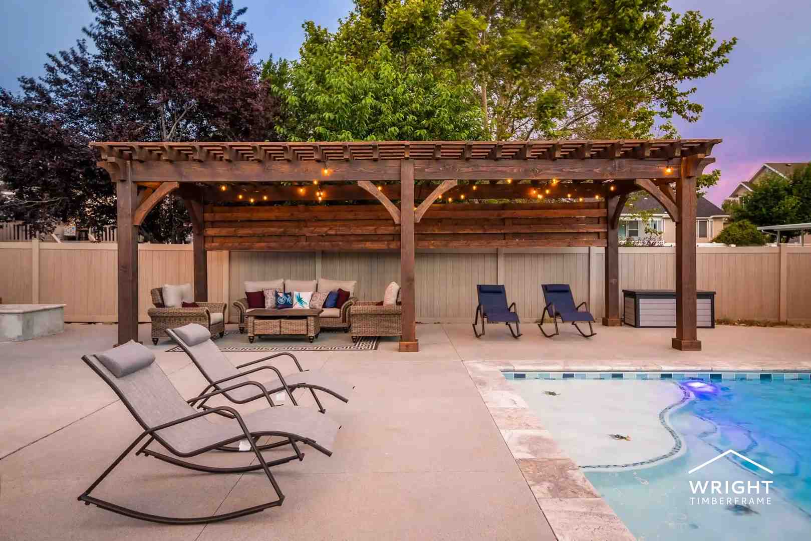 Custom Pergolas for Poolside Outdoor Living Large custom pergolas built beside a backyard pool, featuring timber beams, string lighting, seating areas, and shaded outdoor living space.