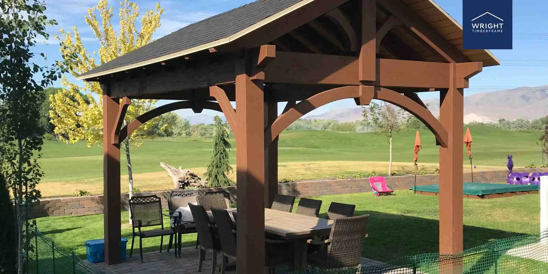 Custom Timber Pavilion Backyard Oasis Custom backyard oasis featuring a timber pavilion with outdoor dining area overlooking landscaped lawn and scenic views