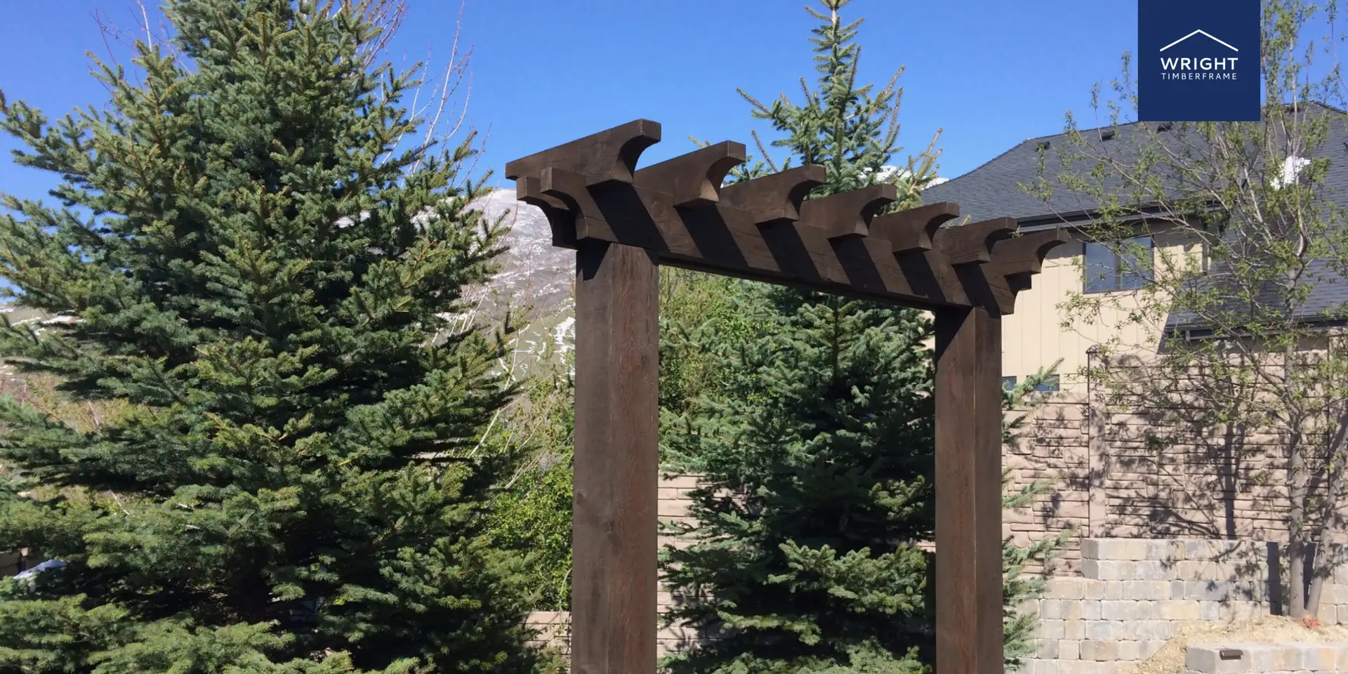Custom Garden Trellis Structures with Pergola Beams Wooden Garden trellis structures with dark timber posts and pergola beams set in a landscaped backyard with trees and stone wall