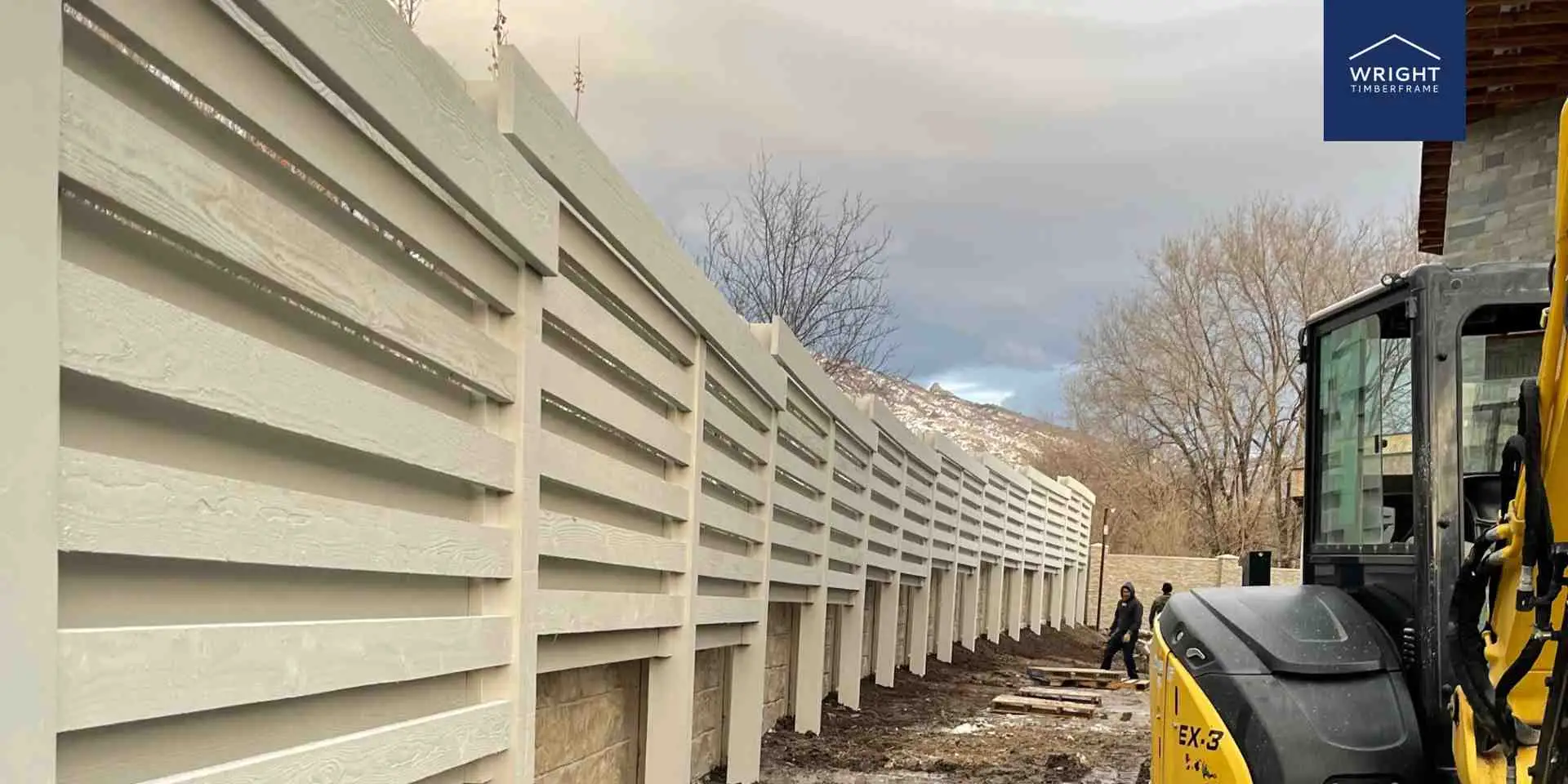 Custom Timber Privacy Trellis Installation Custom backyard oasis privacy wall with timber trellis panels installed along landscaped property line with mountain backdrop