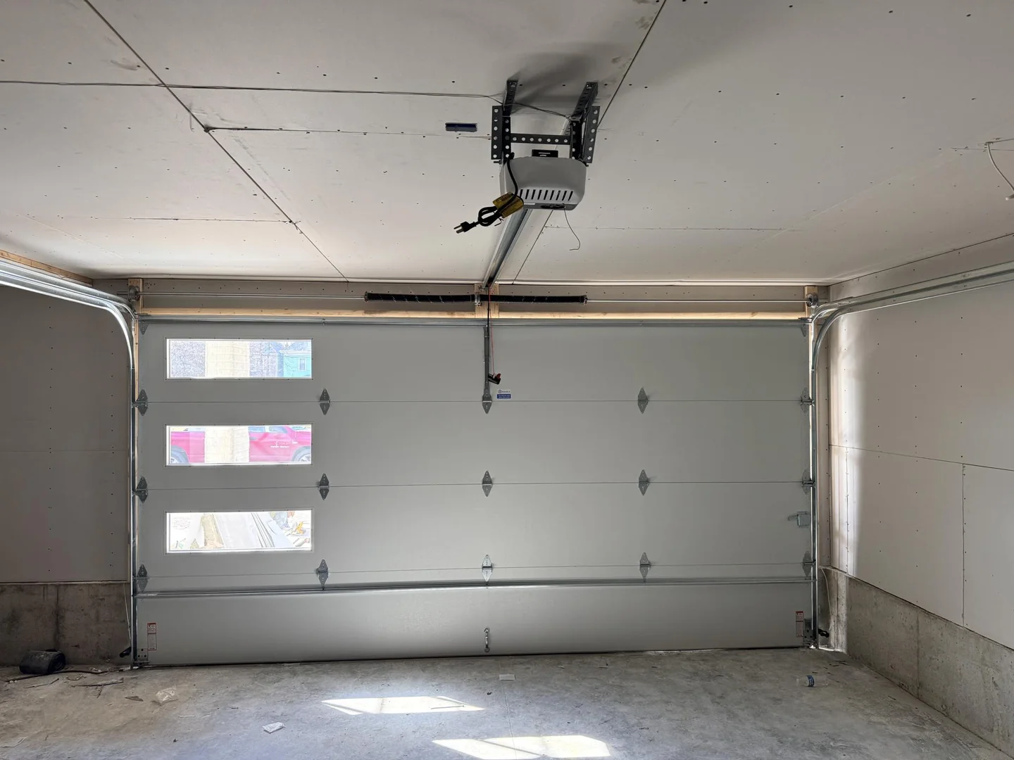 Locking pliers clamped tightly to a garage door track to prevent the door from falling - garage door cable came off drum