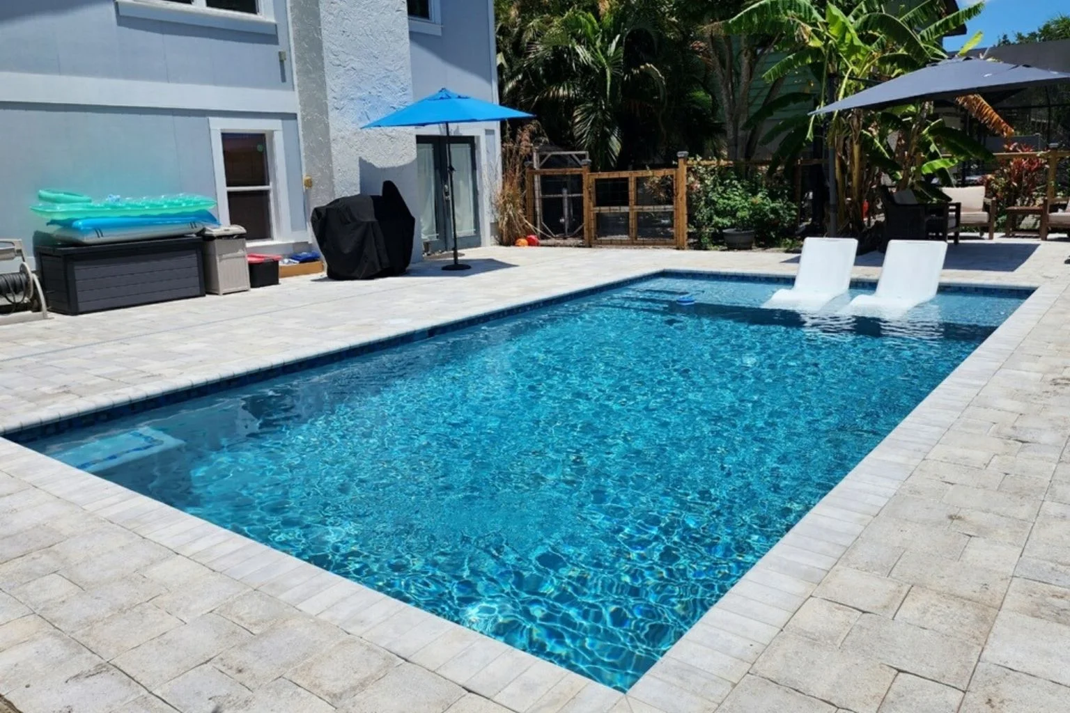 Smart rectangle pool with water feature, controlled by pool automation systems.