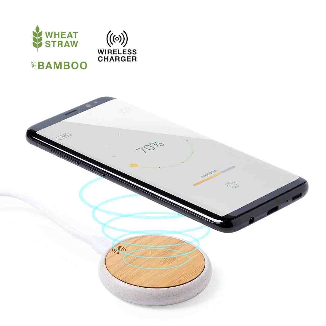 Bamboo wireless charger with a smartphone placed on top, set on a wooden desk - sustainable corporate gift ideas