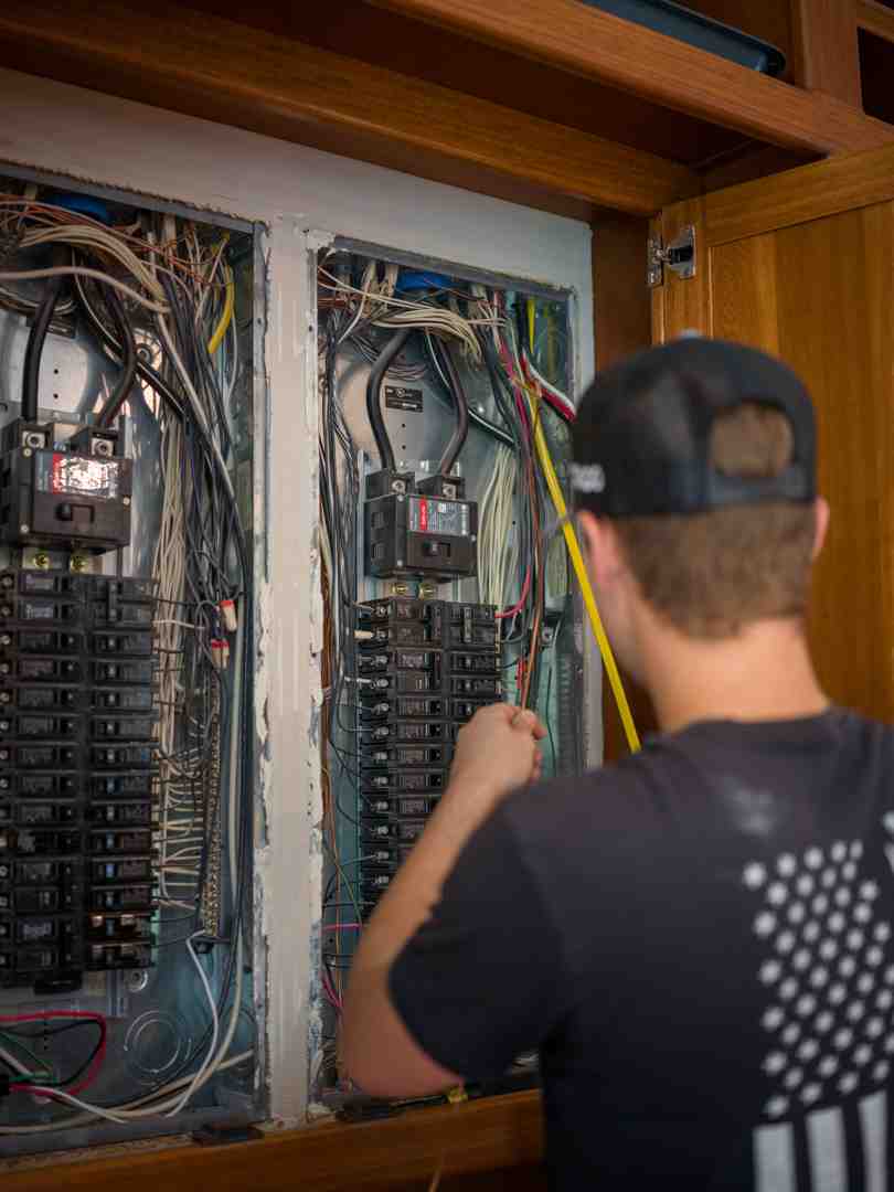 licensed electrician carefully mounting an outlet box on vinyl siding - new exterior outlet boxes in Mooresville