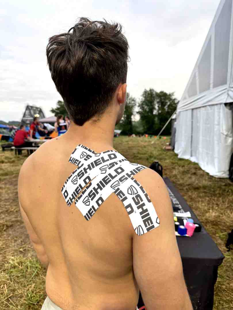 Physical therapist applying kinesiology tape to a patient's shoulder - local sports tape USA Physical therapist applying kinesiology tape to a patient's shoulder - local sports tape USA