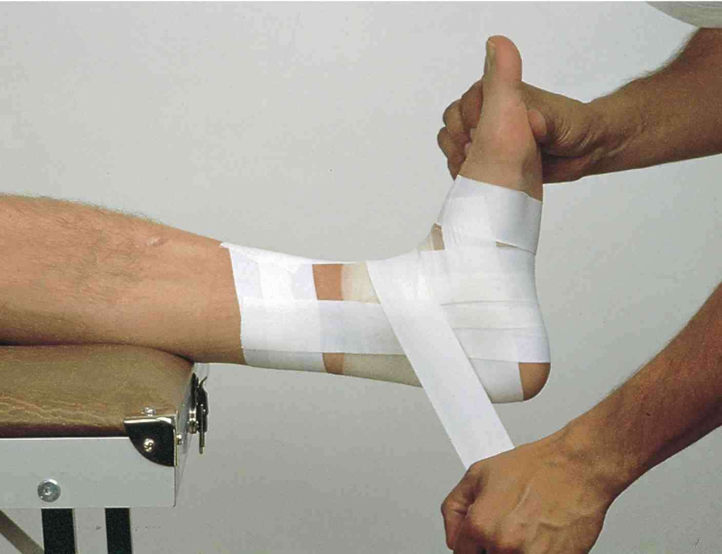 Step-by-step sequence showing proper ankle taping technique including foot positioning, anchor strips, stirrup application, and figure-eight patterns - ankle taping soccer