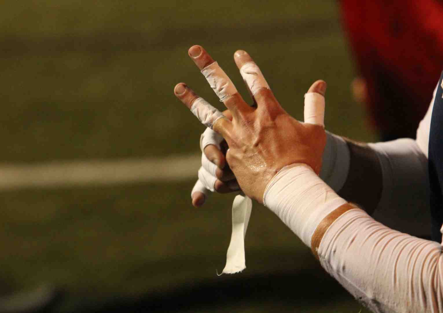 Athlete using different tapes for fingers and wrist - rigid cotton tape for wrists, stretch tape for fingers Athlete using different tapes for fingers and wrist - rigid cotton tape for wrists, stretch tape for fingers
