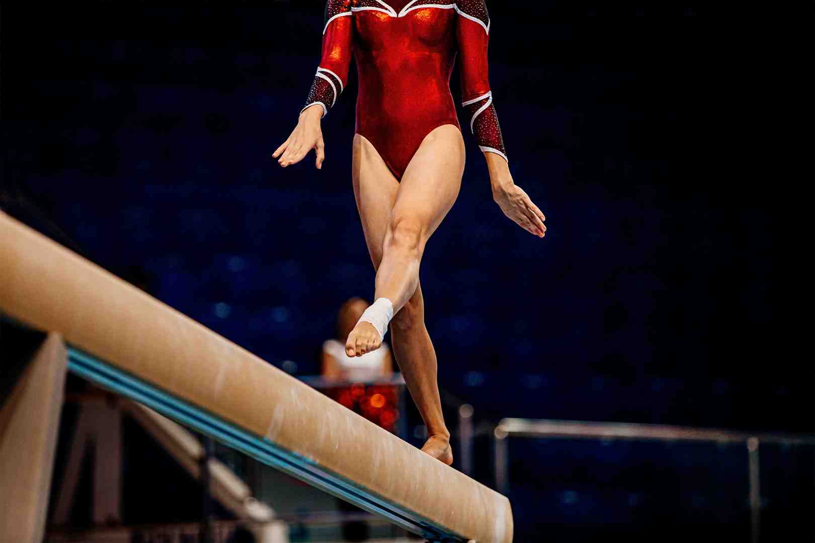 Close-up demonstration of proper wrist taping technique showing the spiral method with anchor strips - athletic tape for gymnastics