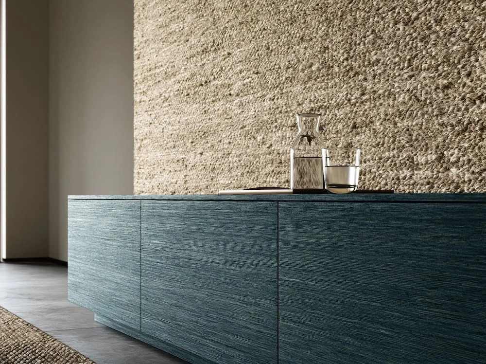 a smooth model cabinet with a glass of water on top against a natural tan color wall