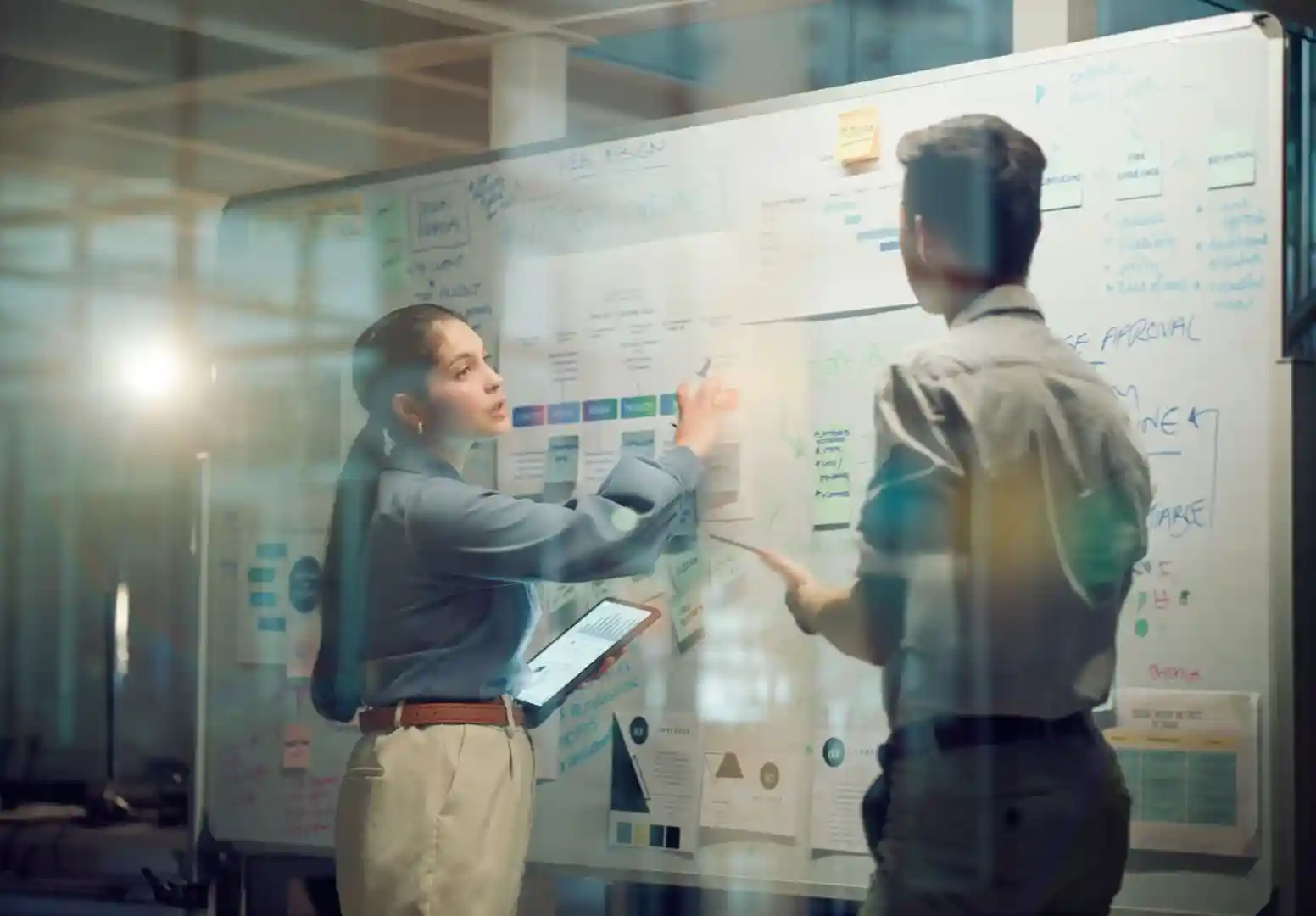 two people collaborating over a whiteboard with marketing funnel diagrams - Digital marketing services