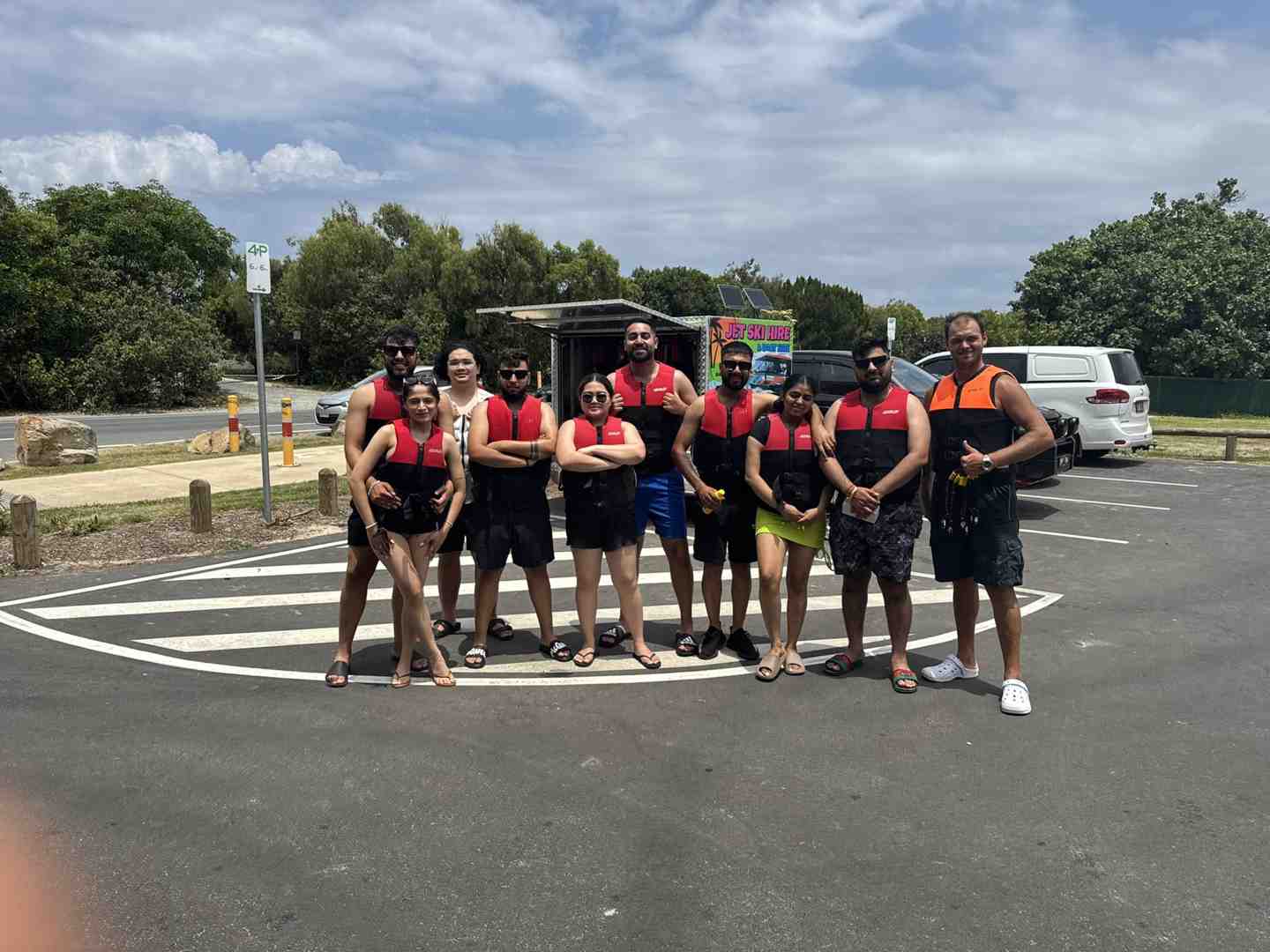 A happy group of nine people wearing life jackets and ready for a jet ski or pontoon tour adventure on a sunny day - First time jet ski A happy group of nine people wearing life jackets and ready for a jet ski or pontoon tour adventure on a sunny day - First time jet ski