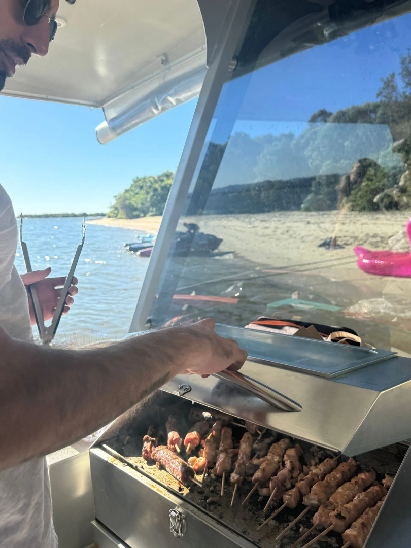 Gold Coast Marine Tours - A customer grilling BBQ sticks with the BBQ grill on the pontoon boat