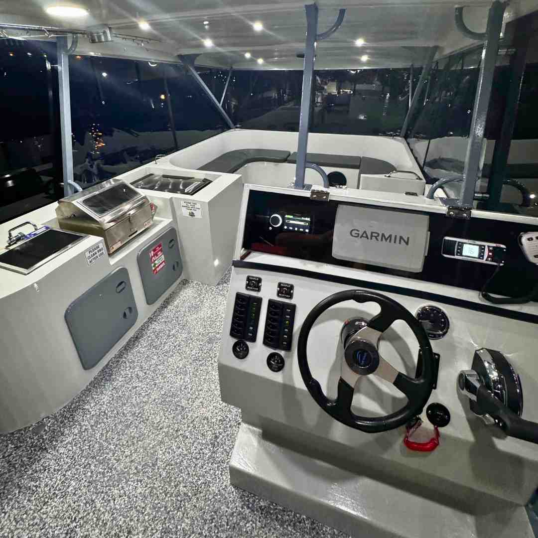 Night interior shot of a Pontoon boat for beginners, featuring the easy-to-navigate helm with a Garmin display, and a built-in BBQ and sink area - Pontoon boat for beginners Night interior shot of a Pontoon boat for beginners, featuring the easy-to-navigate helm with a Garmin display, and a built-in BBQ and sink area - Pontoon boat for beginners