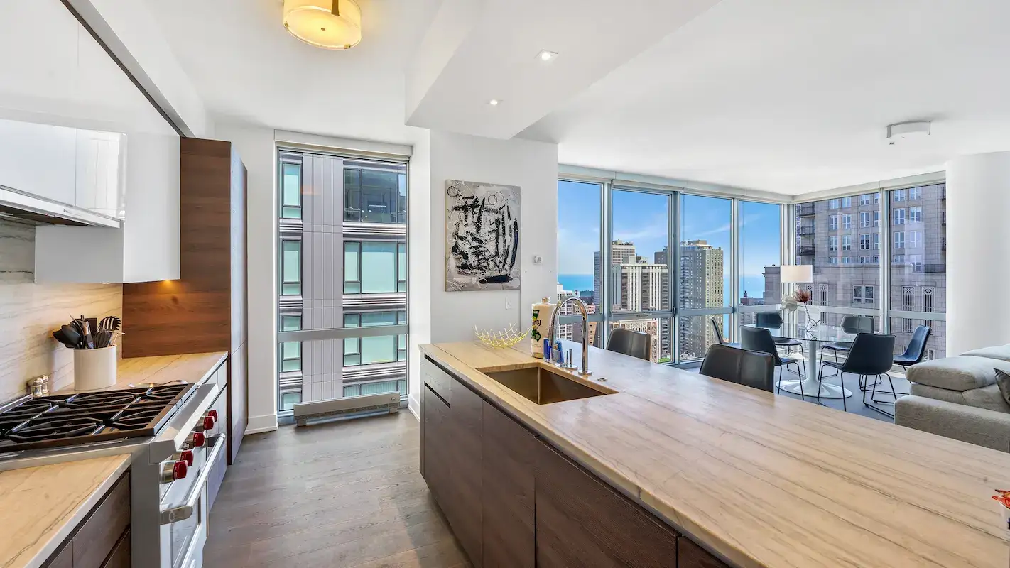 high-end kitchen with quartz countertops and stainless steel appliances - do luxury apartments come furnished