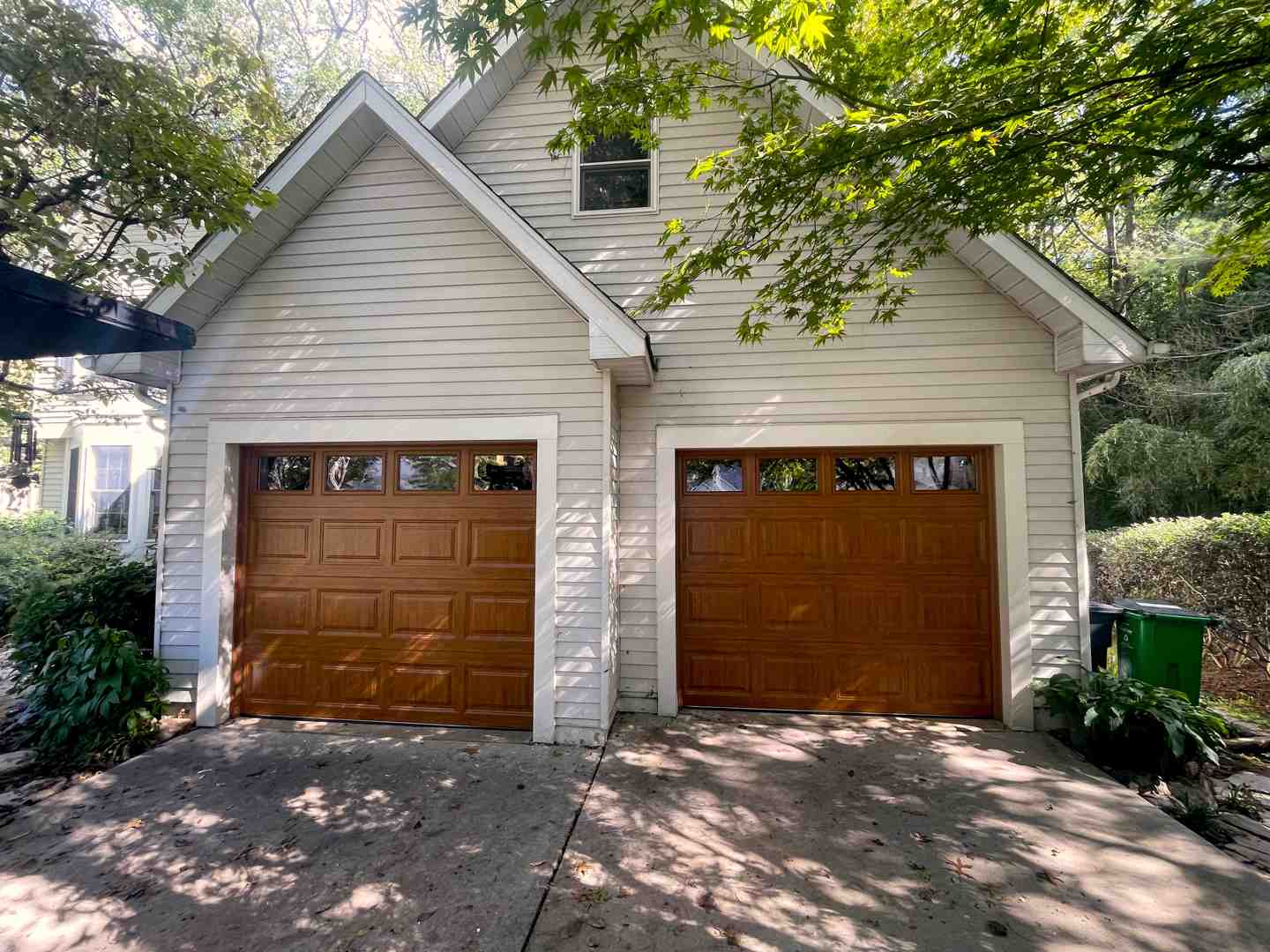 Infographic showing the main components of a garage door system including torsion springs at the top, vertical tracks on both sides, horizontal rollers inside the tracks, a garage door opener motor mounted to the ceiling, safety sensors at the bottom corners, cables running from the bottom brackets to the springs, and sectional panels making up the door face - top rated garage door repair in easton, md