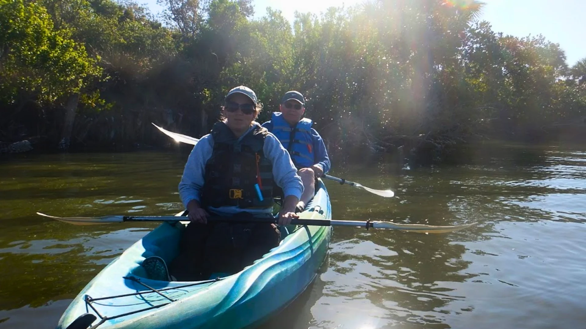 Guided kayak tour paddling through a shaded Florida mangrove tunnel Guided kayak tour paddling through a shaded Florida mangrove tunnel