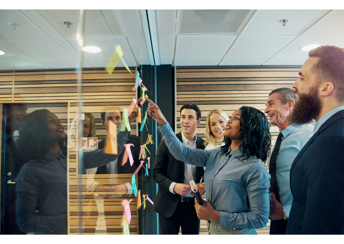 Image of a diverse team collaborating around a whiteboard with charts and graphs, symbolizing a successful CRO program - CRO A/B testing